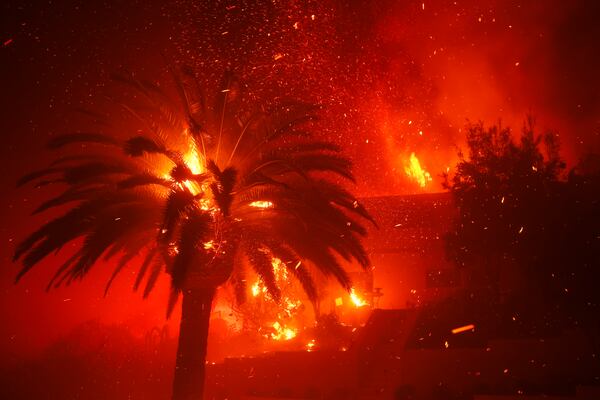 The Palisades Fire burns trees and homes in the Pacific Palisades neighborhood of Los Angeles, Tuesday, Jan. 7, 2025. (AP Photo/Etienne Laurent)