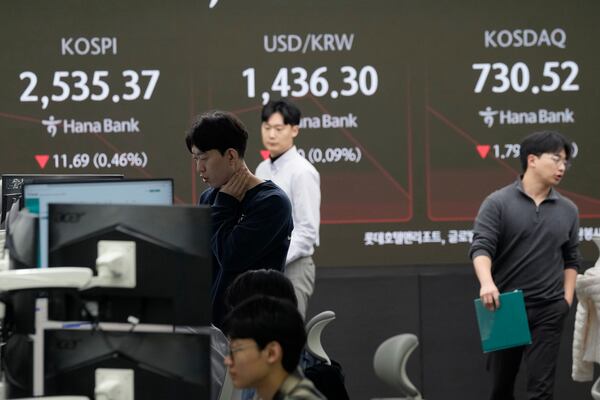 Currency traders work near a screen showing the Korea Composite Stock Price Index (KOSPI), top left, and the foreign exchange rate between U.S. dollar and South Korean won, top center, at the foreign exchange dealing room of the KEB Hana Bank headquarters in Seoul, South Korea, Thursday, Jan. 23, 2025. (AP Photo/Ahn Young-joon)