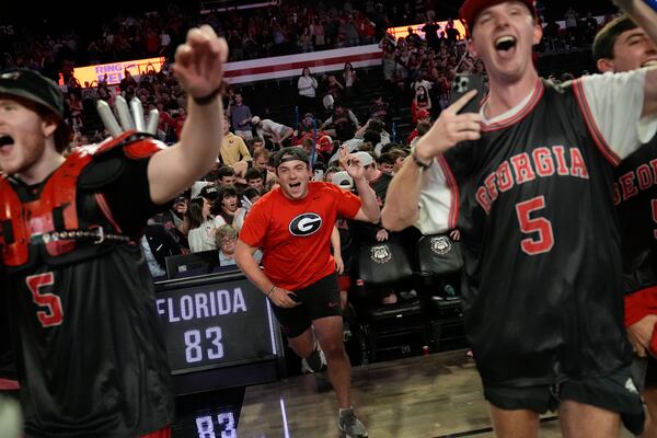 Georgia fans rush the court in celebration after an NCAA college basketball game against Florida, Tuesday, Feb. 25, 2025, in Athens, Ga. (AP Photo/Brynn Anderson)