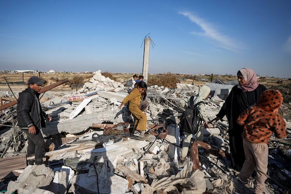 Members of the Abu Sheiban family salvage what they can of their belongings from under rubble of their destroyed home, days after the ceasefire deal between Israel and Hamas, in Rafah, southern Gaza Strip, Tuesday, Jan. 21, 2025. (AP Photo/Abdel Kareem Hana)