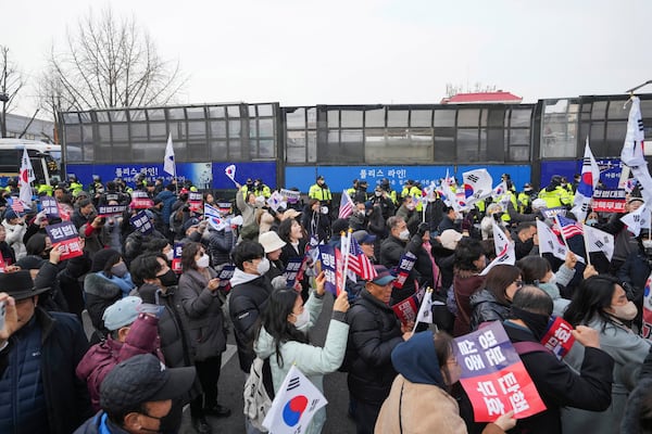 Supporters of impeached South Korean President Yoon Suk Yeol gather as police officers block the road to the Constitutional Court in Seoul, South Korea, Tuesday, Jan. 21, 2025. The letters read "Nullity Impeachment" (AP Photo/Lee Jin-man)