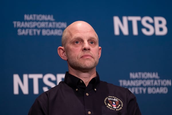 Investigator in charge Brice Banning listens as National Transportation Safety Board (NTSB) Chairwoman Jennifer Homendy speaks about the recent mid-air collision of an American Airlines flight and a Black Hawk helicopter near Ronald Reagan Washington National Airport, at a news conference in Washington, Tuesday, March 11, 2025. (AP Photo/Ben Curtis)