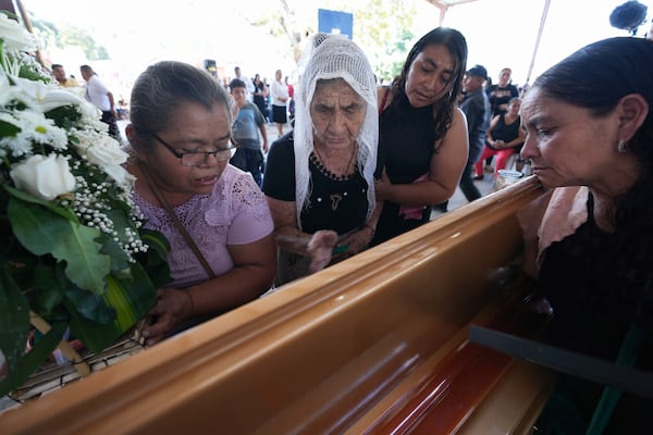 Mourners pay their final respects to the victim of a bus crash at a funeral service in Santo Domingo Los Ocotes, Guatemala, Tuesday, Feb. 11, 2025. Dozens of passengers died after their bus plunged into a gorge and landed under a bridge on Feb. 10 on the outskirts of Guatemalan capital. (AP Photo/Moises Castillo)