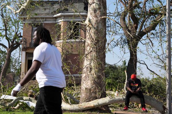 Steven Lampink sits on a downed tree after a severe storm moved through St. Louis, Missouri, Friday, May 16, 2025. (AP Photo/Jeff Roberson)