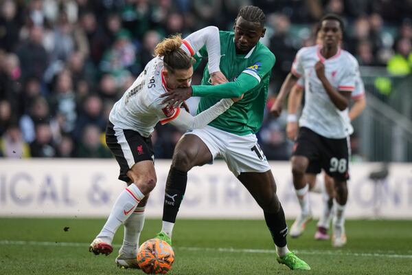 Liverpool's Kostas Tsimikas, left, challenges for the ball in the penalty area with Plymouth Argyle's Mustapha Bundu during the English FA Cup fourth round soccer match between Plymouth Argyle and Liverpool at Home Park stadium in Plymouth, England, Sunday, Feb. 9, 2025. (AP Photo/Alastair Grant)