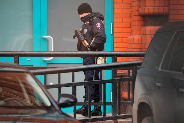 A police officer stands guard in the yard of an upscale residential block in Moscow, Russia, Monday, Feb. 3, 2025, where the blast has killed one person and wounded four others, Russian news agencies say. (AP Photo/Alexander Zemlianichenko)