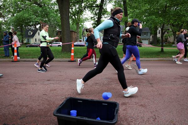 A runner discards their Hiccup, a reusable silicone cup, during the PNC Women Run the Cities race on Saturday, May 17, 2025, in Minneapolis. (AP Photo/Ellen Schmidt)