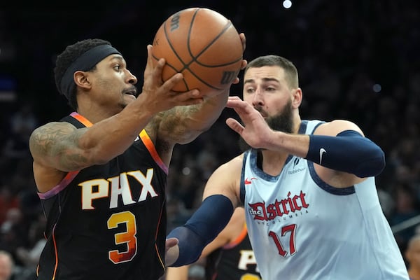 Phoenix Suns guard Bradley Beal (3) drives past Washington Wizards center Jonas Valanciunas (17) during the second half of an NBA basketball game Saturday, Jan. 25, 2025, in Phoenix. (AP Photo/Ross D. Franklin)