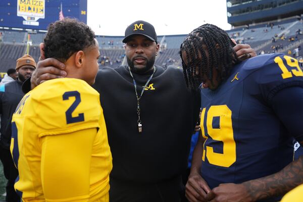 Michigan head coach Sherrone Moore, center, talks with quarterbacks Jadyn Davis (2) and Bryce Underwood (19) after an NCAA college football spring game in Ann Arbor, Mich., Saturday, April 19, 2025. (AP Photo/Paul Sancya)