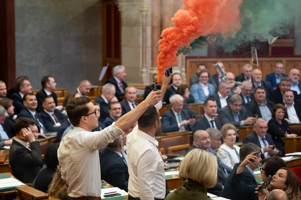 MPs of Momentum protest with flares during the plenary session of the Hungarian parliament in Budapest, Hungary, Tuesday, March 18, 2025. (Boglarka Bodnar/MTI via AP)