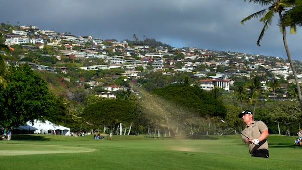 Patrick Fishburn chips onto the 18th green during the third round of the Sony Open golf tournament, Saturday, Jan. 11, 2025, at Waialae Country Club in Honolulu. (AP Photo/Matt York)