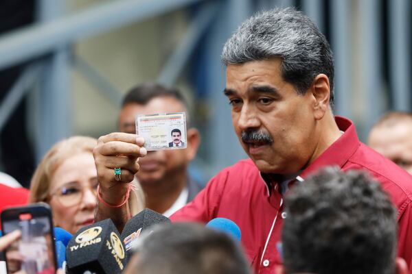 Venezuela's President Nicolas Maduro shows his ID to journalists after voting in legislative and local elections in Caracas, Venezuela, Sunday, May 25, 2025. (AP Photo/Cristian Hernandez)