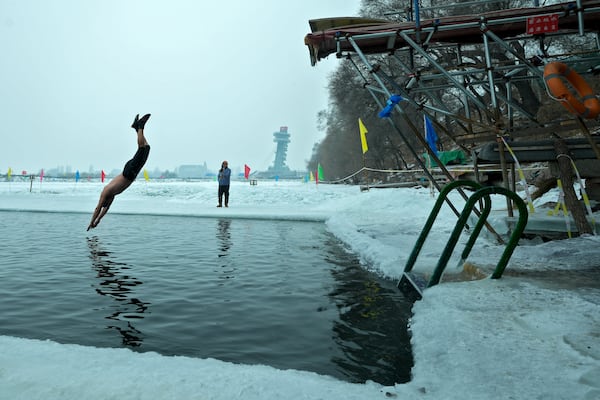 A man jumps into a pool carved from ice on the frozen Songhua river in Harbin in northeastern China's Heilongjiang province, Tuesday, Jan. 7, 2025. (AP Photo/Andy Wong)