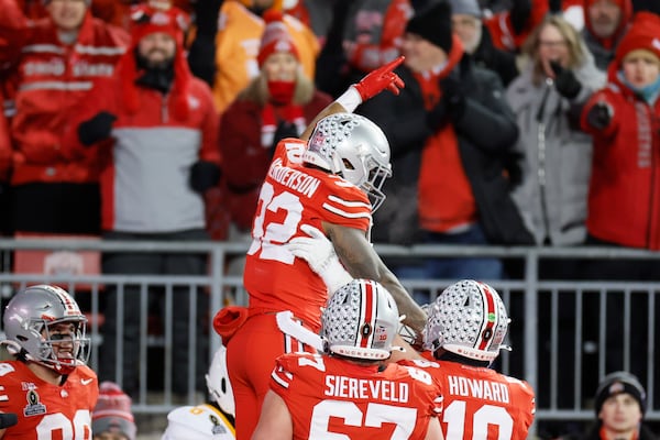 Ohio State running back TreVeyon Henderson, top, celebrates after his touchdown against Tennessee during the first half in the first round of the College Football Playoff, Saturday, Dec. 21, 2024, in Columbus, Ohio. (AP Photo/Jay LaPrete)