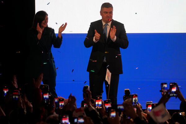 President incumbent Zoran Milanovic with his wife Sanja Music Milanovic greets supporters as the preliminary results grant him victory in a runoff vote for the Croatian presidential election in Zagreb, Croatia, Sunday, Jan. 12, 2025. The sign reads "Thank You". (AP Photo/Darko Bandic)