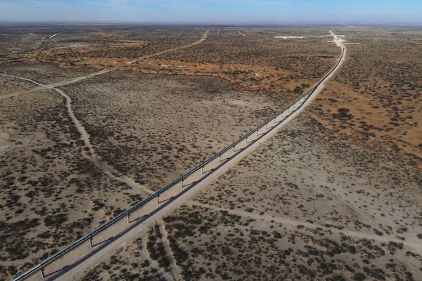 With New Mexico seen at a distance, a 42-mile conveyor belt by Atlas Energy carries sand needed for hydraulic fracturing Wednesday, Feb. 26, 2025, in Kermit, Texas. (AP Photo/Julio Cortez)