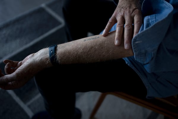 At his home in Haifa, Israel, Holocaust survivor Naftali Fürst shows the numbers that were tattooed on his arm when he was imprisoned at Auschwitz, Tuesday, Jan. 14, 2025. (AP Photo/Maya Alleruzzo)