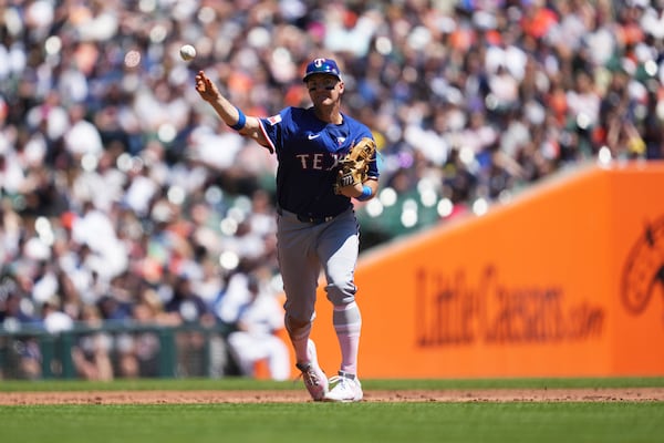 Texas Rangers third baseman Josh Jung throws to first base for an out on a Detroit Tigers' Zach McKinstry ground ball in the second inning during a baseball game, Sunday, May 11, 2025, in Detroit. (AP Photo/Paul Sancya)