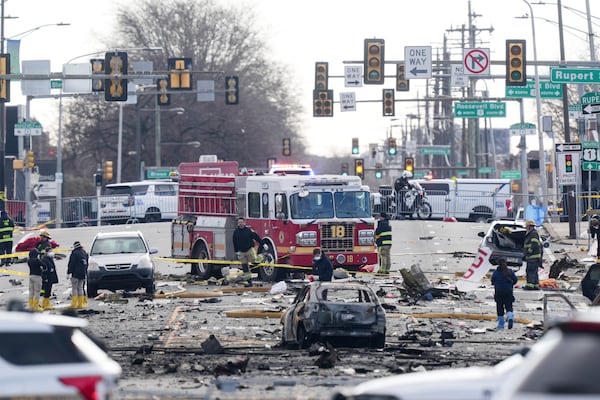 Investigators work the scene after a small plane crashed in Philadelphia, Saturday, Feb. 1, 2025. (AP Photo/Matt Rourke)