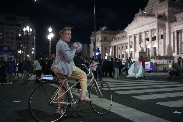 Adriana Reygadas, 71, bangs pots outside Congress during a protest for higher pensions and against austerity measures implemented by Javier Milei's government in Buenos Aires, Argentina, Wednesday, March 12, 2025. (AP Photo/Rodrigo Abd)