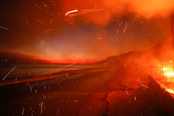 The Palisades Fire burns a beach front property Wednesday, Jan. 8, 2025 in Malibu, Calif. (AP Photo/Etienne Laurent)