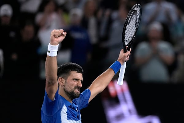 Novak Djokovic of Serbia celebrates after defeating Carlos Alcaraz of Spain in their quarterfinal match at the Australian Open tennis championship in Melbourne, Australia, Wednesday, Jan. 22, 2025. (AP Photo/Ng Han Guan)