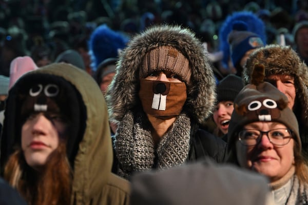 FILE - Gloria McGowan of Williamsport, Ind., center, watches the festivities while waiting for Punxsutawney Phil, the weather prognosticating groundhog, to come out and make his prediction during the 136th celebration of Groundhog Day on Gobbler's Knob in Punxsutawney, Pa., Wednesday, Feb. 2, 2022. (AP Photo/Barry Reeger, File)