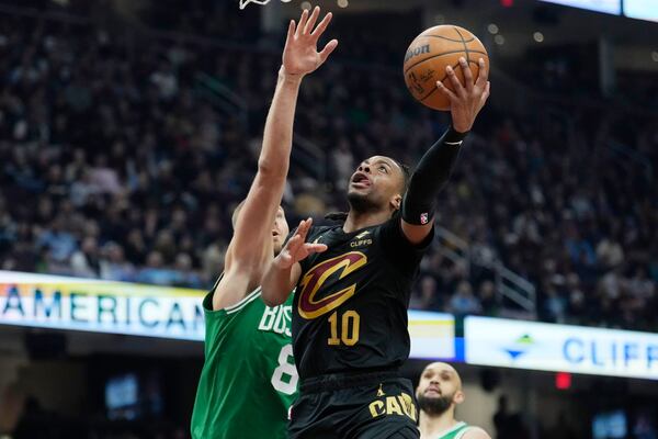 Cleveland Cavaliers guard Darius Garland (10) shoots in front of Boston Celtics center Kristaps Porzingis (8) in the first half of an NBA basketball game, Tuesday, Feb. 4, 2025, in Cleveland. (AP Photo/Sue Ogrocki)