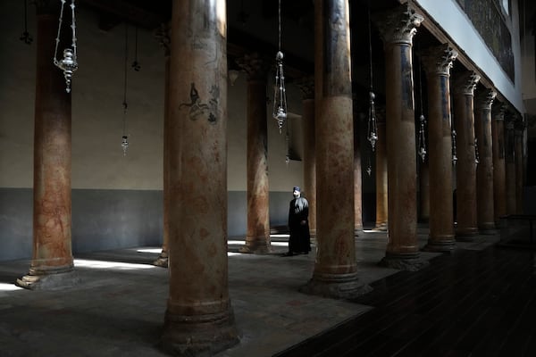 A priest walks in the Church of the Nativity, where Christians believe Jesus Christ was born, ahead of Christmas in the West Bank city of Bethlehem, Tuesday, Dec. 17, 2024. (AP Photo/Mahmoud Illean)