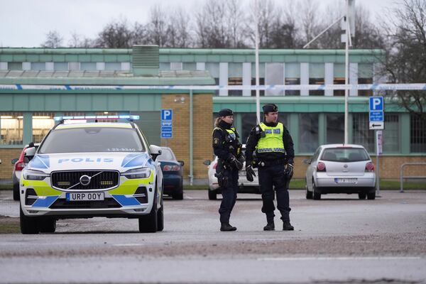 Police officers stand guard near the scene of a shooting at an adult education center on the outskirts of Orebro, Sweden, Wednesday, Feb. 5, 2025. (AP Photo/Sergei Grits)