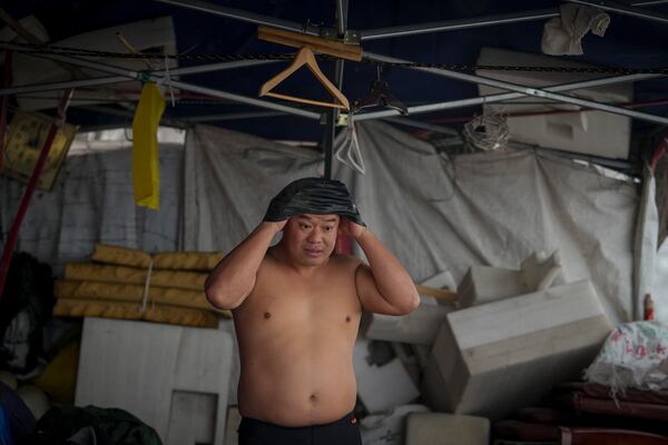 A man puts on his head cover as he prepares to swim in the frozen Songhua river in Harbin in northeastern China's Heilongjiang province, Tuesday, Jan. 7, 2025. (AP Photo/Andy Wong)