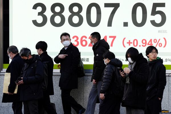 People walk in front of an electronic stock board showing Japan's Nikkei index at a securities firm Thursday, Jan. 16, 2025, in Tokyo. (AP Photo/Eugene Hoshiko)