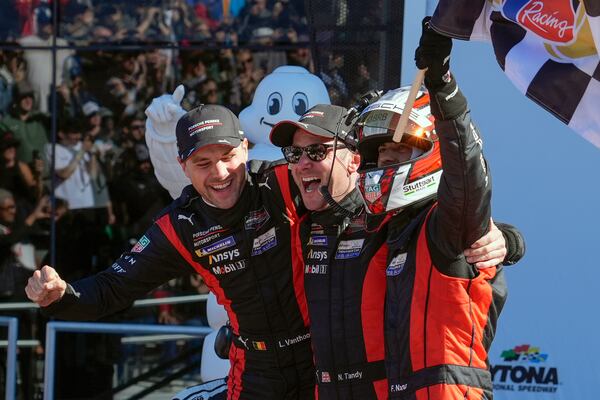 Porsche Penske Motorsports team winners, from left to right, Belgium's Laurens Vanthoor, Britain's Nick Tandy and Brazil's Felipe Nasr celebrate in Victory Lane after winning the IMSA Rolex 24 hour auto race at Daytona International Speedway, Sunday, Jan. 26, 2025, in Daytona Beach, Fla. (AP Photo/John Raoux)