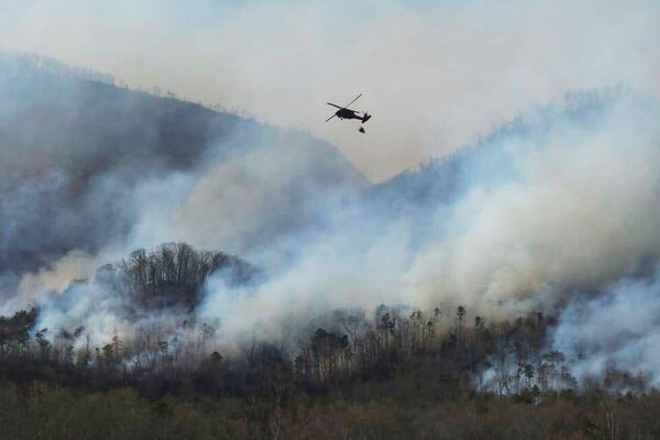 In this March 23, 2025, photo released by the U.S. National Guard shows a UH-60 Black Hawk helicopter from the 1-111th General Support Aviation Battalion, 59th Aviation Troop Command, McEntire Joint National Guard Base in Eastover executing its fire suppression mission in support of the South Carolina Forestry Commission at Persimmon Ridge Fire near Greenville, S.C. (Sgt. 1st Class Roberto Di Giovine/U.S. Army National Guard via AP)