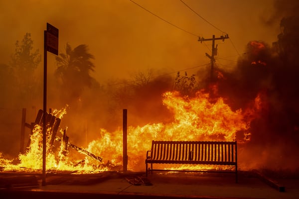 The Eaton Fire burns a bus stop Wednesday, Jan. 8, 2025 in Altadena, Calif. (AP Photo/Ethan Swope)