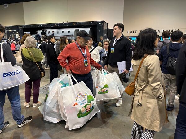 Berkshire Hathaway shareholder Devan Bisher holds five large bags filled with Warren Buffett and Charlie Munger Squishmallows while waiting in line on Friday, May 2, 2025 in Omaha, Neb. (AP Photo/Josh Funk)