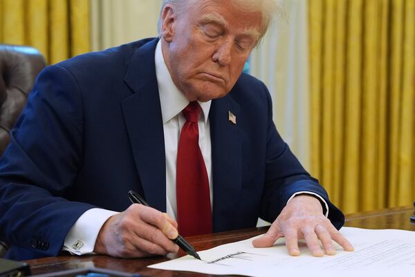 President Donald Trump signs a document in the Oval Office at the White House, Thursday, Jan. 30, 2025, in Washington. (AP Photo/Evan Vucci)