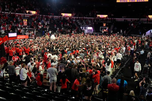 Georgia fans rush the court in celebration after an NCAA college basketball game against Florida, Tuesday, Feb. 25, 2025, in Athens, Ga. (AP Photo/Brynn Anderson)