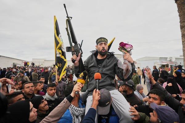 Freed Palestinian prisoners are greeted by a crowd as they arrive in the Gaza Strip after being released from an Israeli prison following a ceasefire agreement between Hamas and Israel in Khan Younis, souther Gaza Strip, Saturday Feb. 8, 2025. (AP Photo/Abdel Kareem Hana)