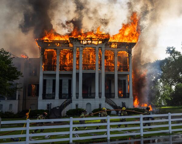 Fire crews mover a line around the now fully engulfed the Nottoway Plantation on Thursday, May 15, 2025 in White Castle, La. (Michael Johnson/The Advocate via AP)