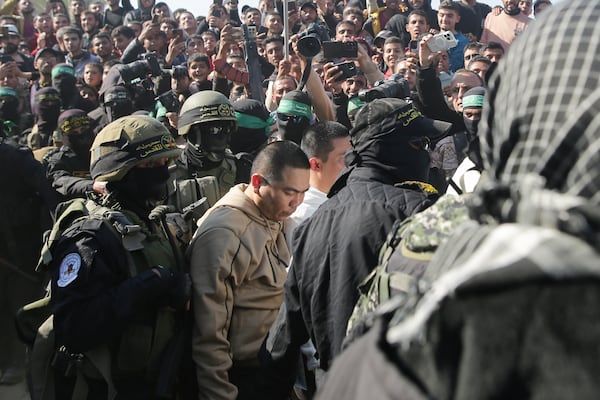 Two Thai captives, who has been held hostage by Hamas in Gaza since October 7, 2023, are escorted by Hamas fighters as they are handed over to the Red Cross in Khan Younis, southern Gaza Strip, Thursday Jan. 30, 2025.(AP Photo/Jehad Alshrafi)