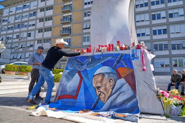 Mexican painter Roberto Marquez places a painting of Pope Francis he made outside the Agostino Gemelli hospital in Rome, Wednesday, March 5, 2025. (AP Photo/Gregorio Borgia)