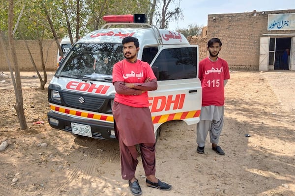 Rescue workers stand beside the ambulance outside a railway station near the attack site of a passenger train by insurgents, in Mushkaf in Bolan district of Pakistan's southwestern Balochistan province, Wednesday, March 12, 2025. (AP Photo)