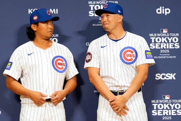 Seiya Suzuki, right, and Shota Imanaga, left, of the Chicago Cubs prepare to pose for photographs after attending the official Press conference Friday, March 14, 2025, in Tokyo, as the Cubs play their MLB opening games against the Los Angeles Dodgers at Tokyo Dome next week. (AP Photo/Eugene Hoshiko)