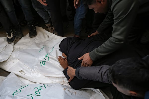 A relative mourns over the body of one of the five Palestinian journalists who were killed by an Israeli airstrike in Gaza City at the Al-Aqsa Hospital in Deir al-Balah, Thursday, Dec. 26, 2024. (AP Photo/Abdel Kareem Hana)