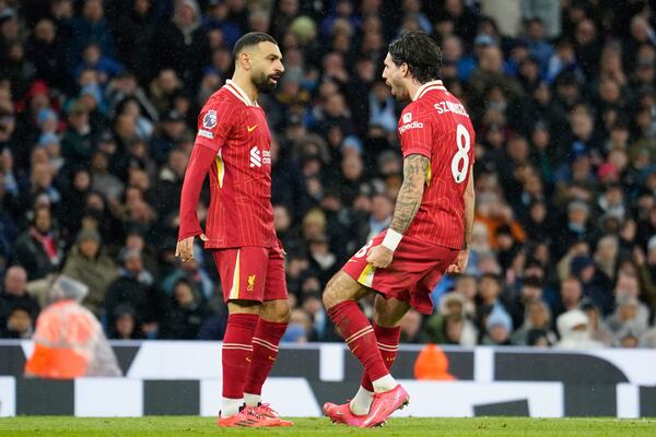 Liverpool's Dominik Szoboszlai, right, celebrates with Mohamed Salah scoring his side's 2nd goal during the English Premier League soccer match between Manchester City and Liverpool at Etihad stadium in Manchester, England, Sunday, Feb. 23, 2025. (AP Photo/Dave Thompson)