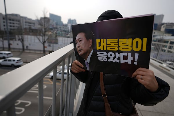 A supporter of impeached South Korean President Yoon Suk Yeol holds a sign near the presidential residence in Seoul, South Korea, Friday, March 7, 2025. The letters read, "President was right." (AP Photo/Lee Jin-man)