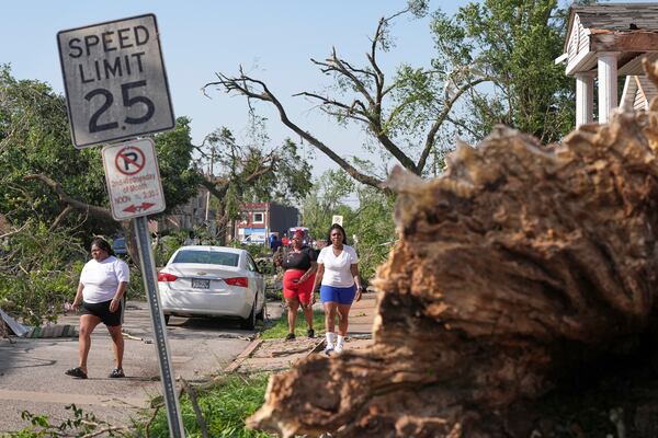 People survey damage after a severe storm moved through Friday, May 16, 2025, in St. Louis. (AP Photo/Jeff Roberson)