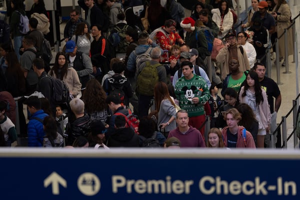 Travelers wait in line for security checks at the Los Angeles International Airport in Los Angeles, Tuesday, Dec. 24, 2024. (AP Photo/Jae C. Hong)