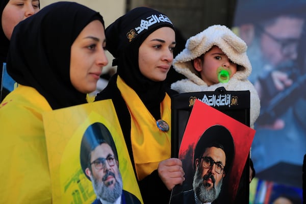 Mourners hold portraits of slain Hezbollah Secretary General Sayyed Hashem Safieddine during his funeral procession in the southern Lebanese village of Deir Qanoun al Nahr, Lebanon, Monday, Feb. 24, 2025. (AP Photo/Mohammad Zaatari)